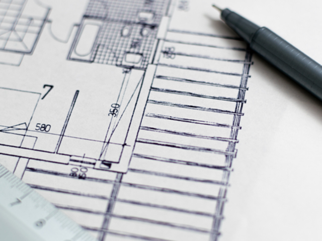 Woman sits at computer operating software programme. 